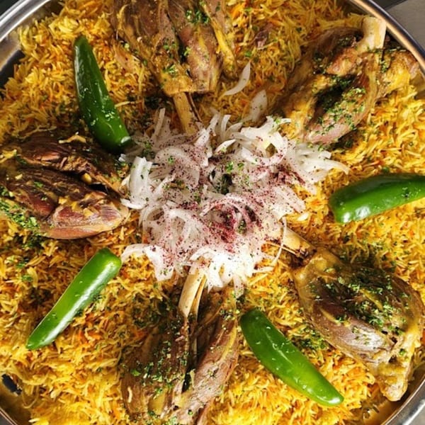 A large platter of Ali Baba Kabab's Mediterranean lamb mandi with rice, onions, and green peppers.